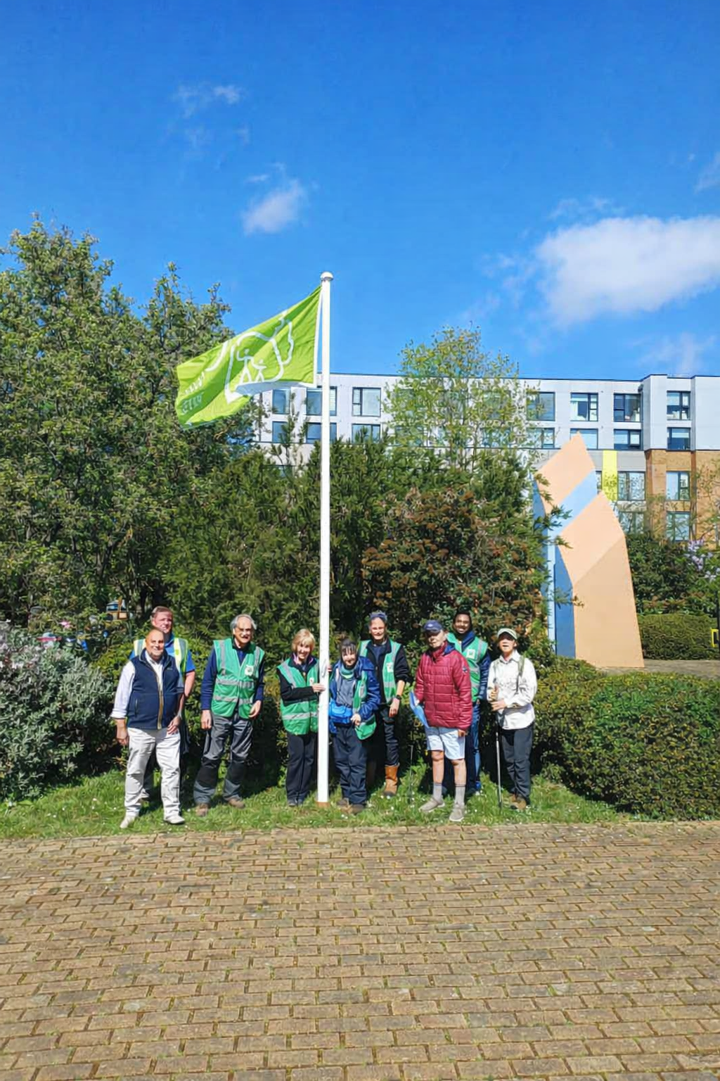 An image showing the team in front of the flagpole flying the Green Flag Award 2025/26 flag